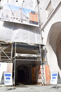 Construction site entrance to the new institute building with signs pointing to the event