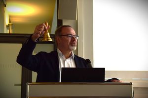 Dietmar Harhoff with the historic event bell